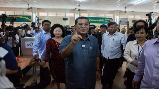 Cambodian Prime Minister Hun Sen shows his stained finger after voting during the Cambodian general elections in Phnom Penh, Cambodia.